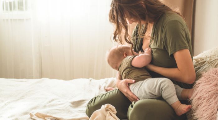 breastfeeding mum latching and breastfeeding her baby or newborn